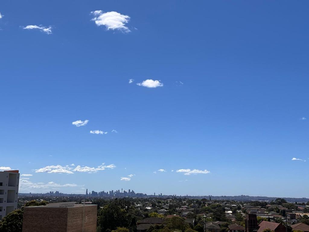 a view of a city with a blue sky at Hurstville New apartment with city view in Sydney