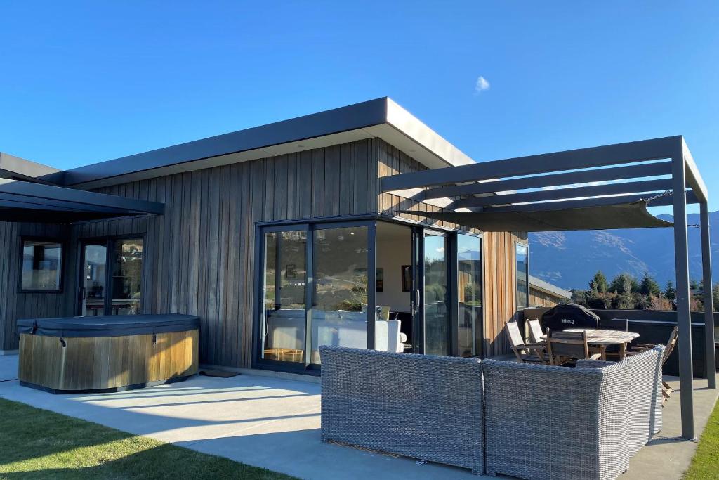 a modern house with a patio with a table at The Yellow Door in Wanaka