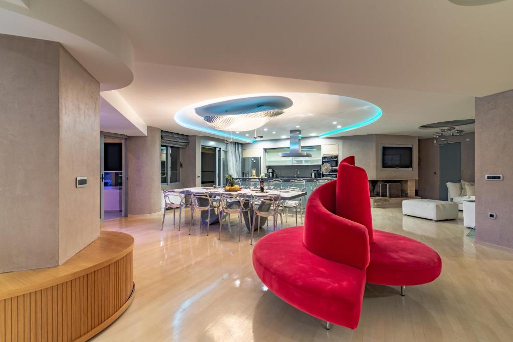 a living room with a red chair and a table at Candia Boulevard in Heraklio Town