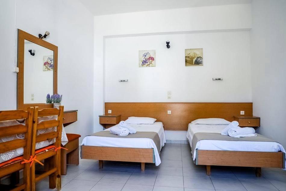 a hotel room with two beds and a mirror at Barvas studios Lindos in Líndos