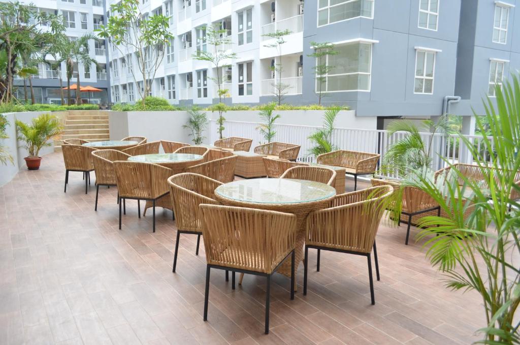 a patio with tables and chairs and a building at Kyriad Hotel Airport Jakarta in Tangerang