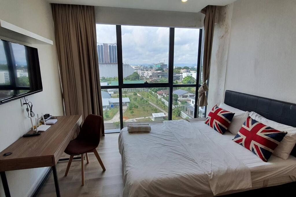 a bedroom with a bed and a desk and a large window at Kozi Square New SGH Cozy Home LV5B in Kuching