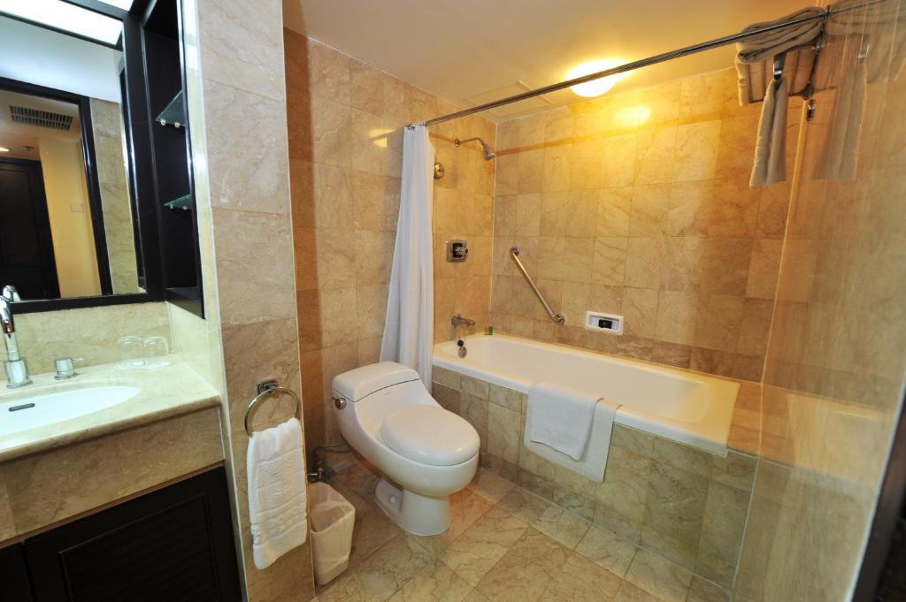 a bathroom with a toilet and a tub and a sink at Hotel Borobudur Jakarta in Jakarta