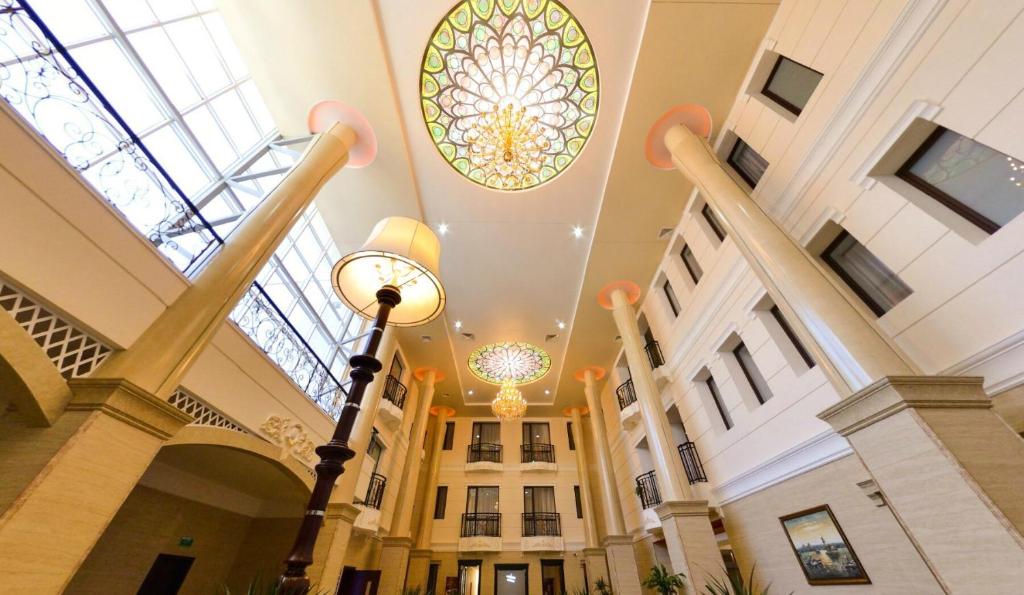 een uitzicht op de lobby van een gebouw met een glas-in-loodplafond bij Gostinichnyy Kompleks Tobol in Qostanaj