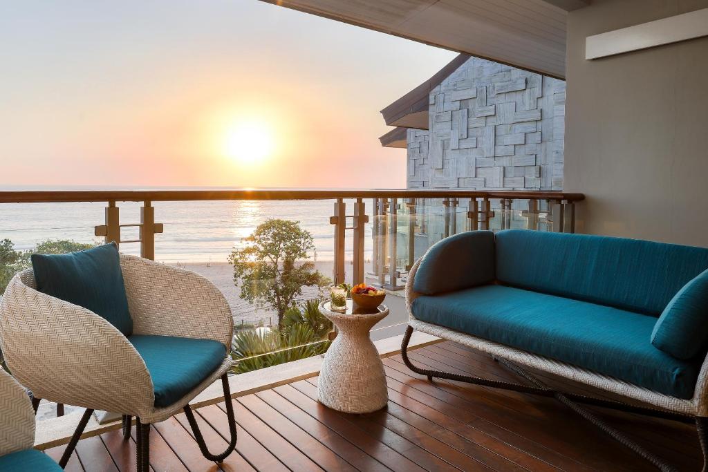 a living room with a couch and chairs on a balcony at Double - Six, Luxury Hotel - Seminyak in Seminyak