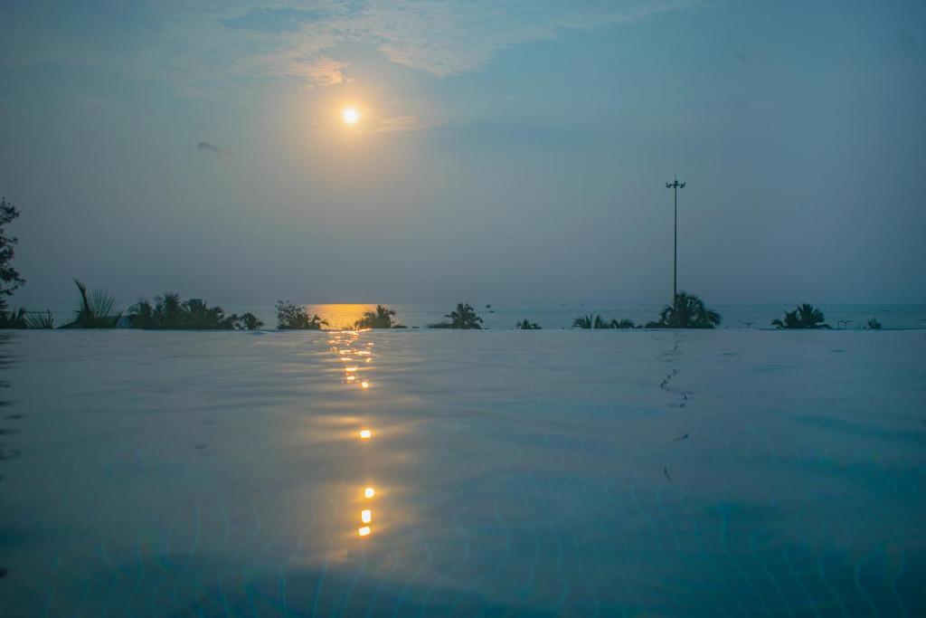 a pool of water with the moon in the sky at Altrude By The Sea in Candolim
