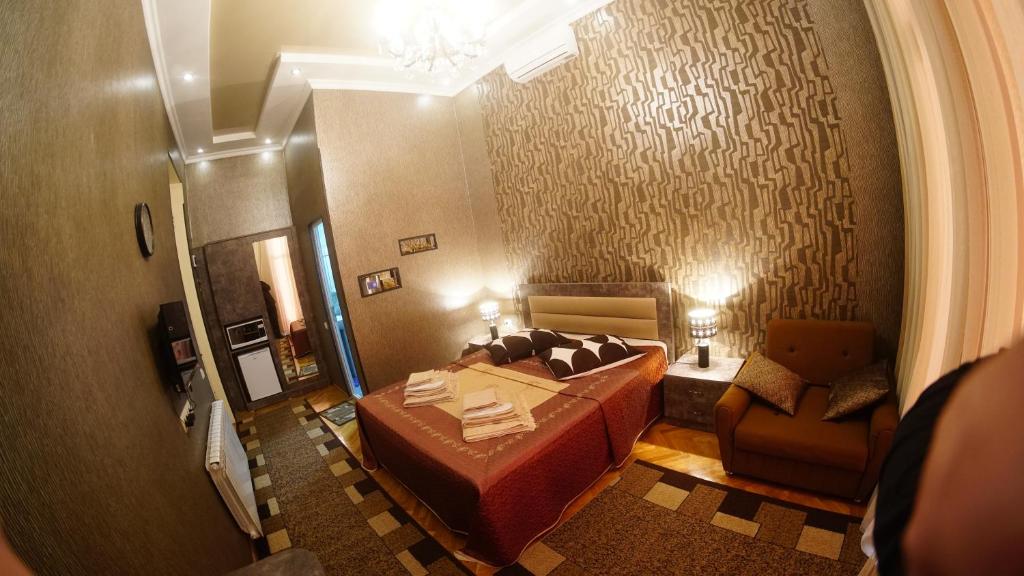 ein Schlafzimmer mit einem Bett und einem Stuhl in einem Zimmer in der Unterkunft ALINA'S ROOM in Kutaissi