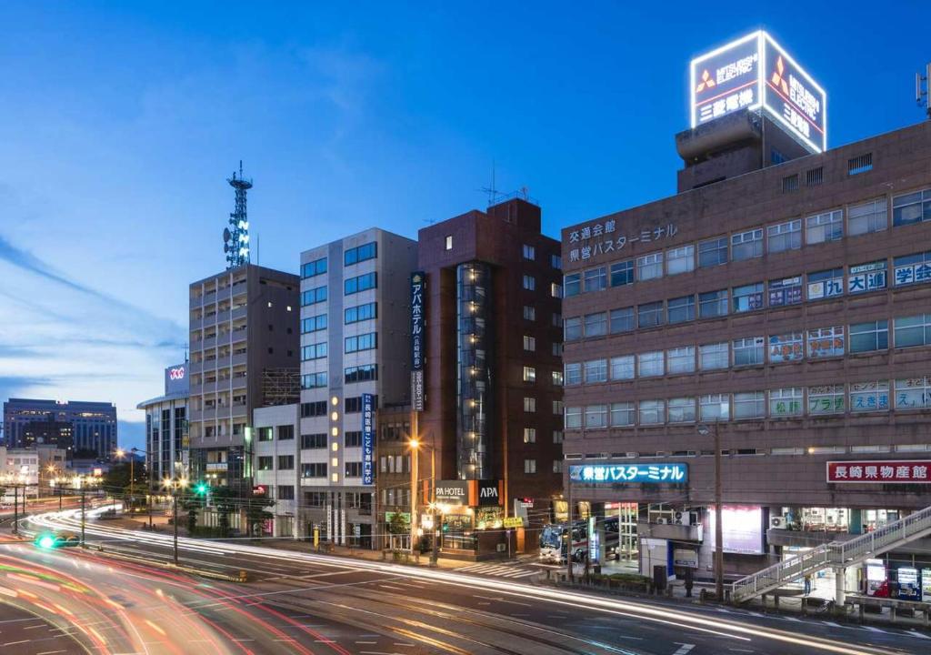 een stadsstraat 's nachts met gebouwen en straatverlichting bij APA Hotel Nagasaki Ekimae in Nagasaki