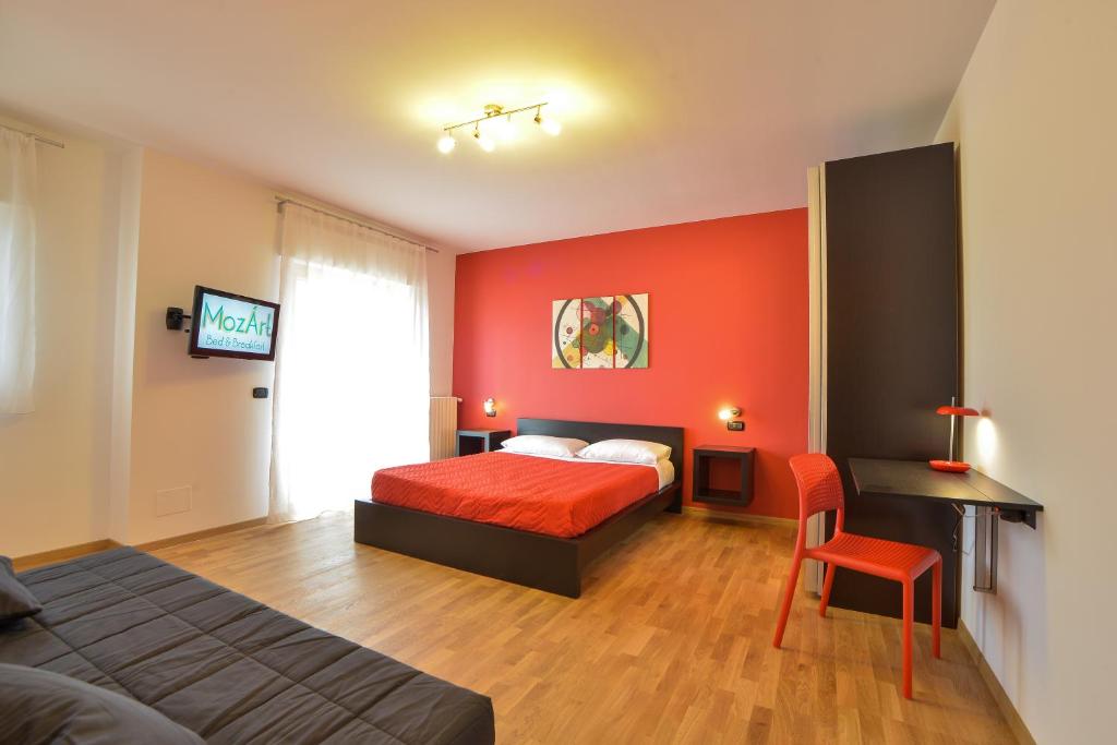 アンドリアにあるMozÁrt Bed & Breakfast - Affittacamereの赤い壁のベッドルーム1室(ベッド1台付)
