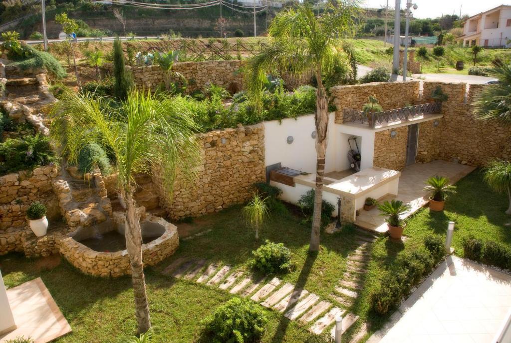 una vista aérea de un jardín con palmeras y un edificio en Pedra Do Sol, en Balestrate