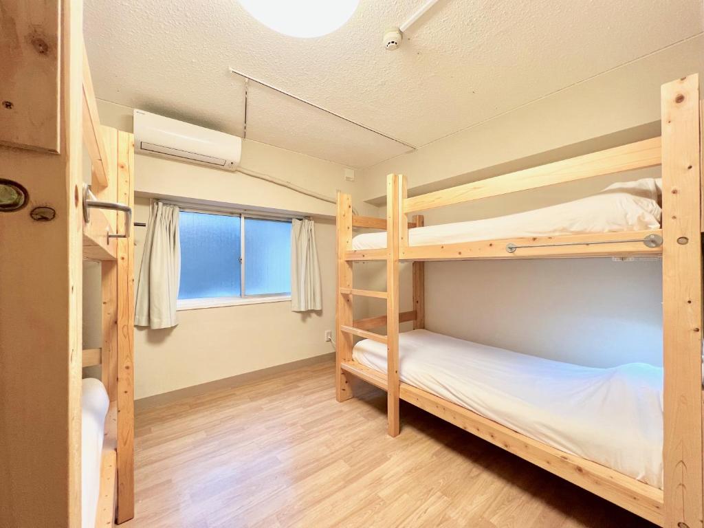 Una cama o camas en una habitación de Glocal Nagoya Backpackers Hostel