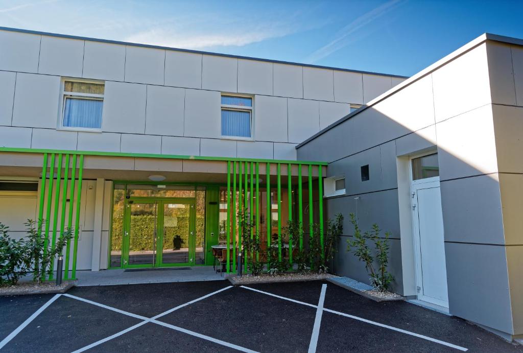 an exterior view of a white building with green gates at Jugendgästehaus Bad Ischl in Bad Ischl