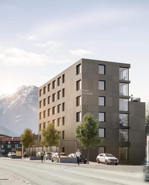 Una representación de un edificio con coches aparcados en el exterior. en ALPSTADT LIFESTYLE Hotel, en Bludenz