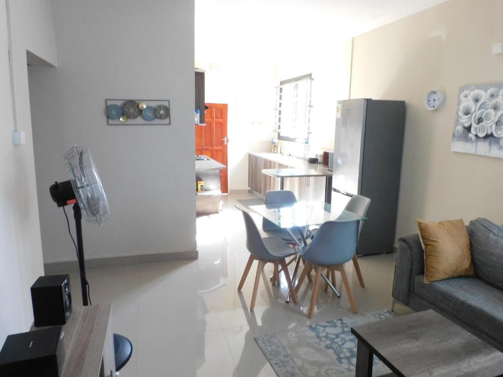 a living room with a couch and a table and chairs at Okavango apartments in Lusaka