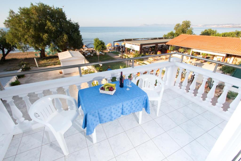 un tavolo e sedie su un balcone con vista sull'oceano di Papidakis Studios ad Agia Marina Nea Kydonias