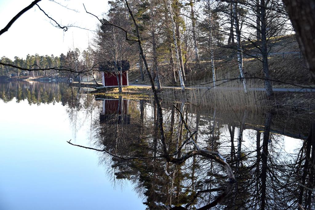 a reflection of a red house in the water at Mullsjö Folkhögskola in Mullsjö
