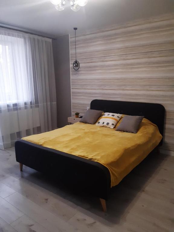 ein Schlafzimmer mit einem großen Bett und einer gelben Decke in der Unterkunft Подолье in Winnyzja