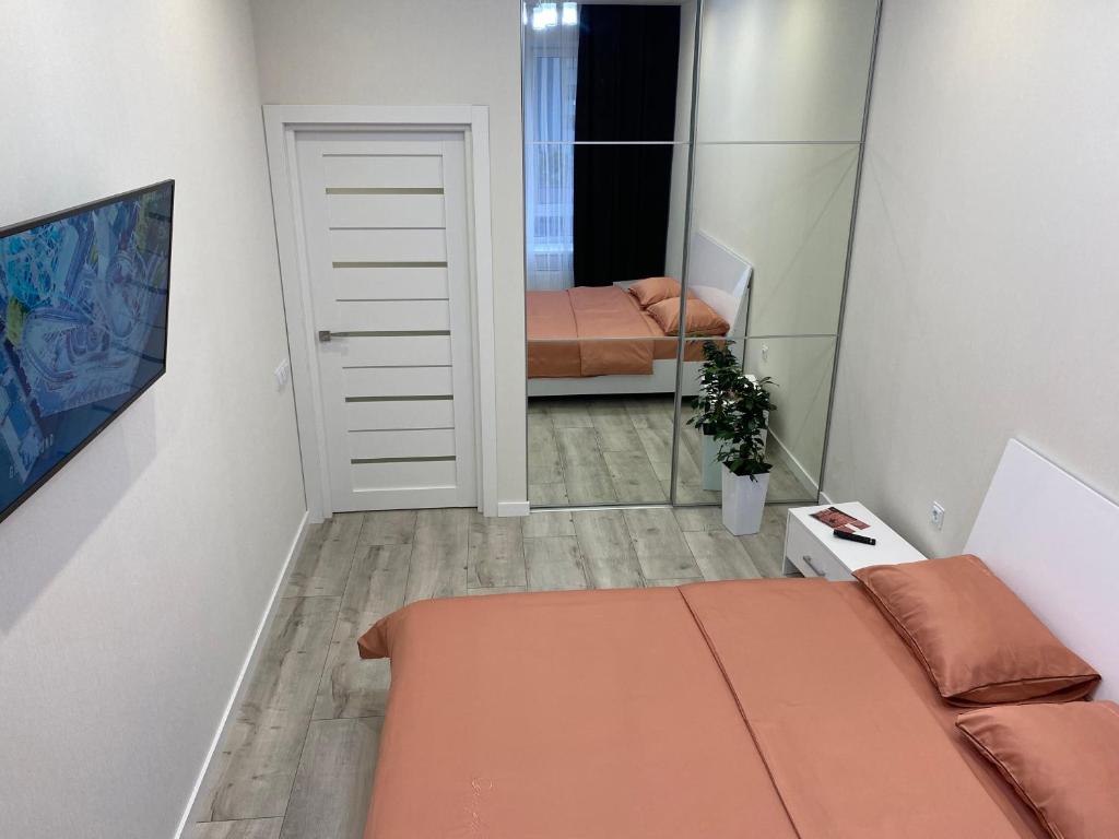 Dormitorio pequeño con cama y espejo en Люкс апартаменти.Новобудова.Центр.ЖК Театральний, en Rivne