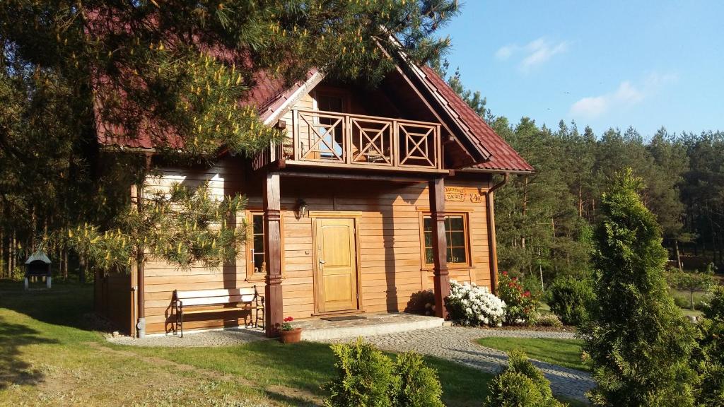 a wooden cabin with a balcony and a porch at Kaszubskie Zacisze dom nad jeziorem, sauna, balia ogrodowa in Lipusz