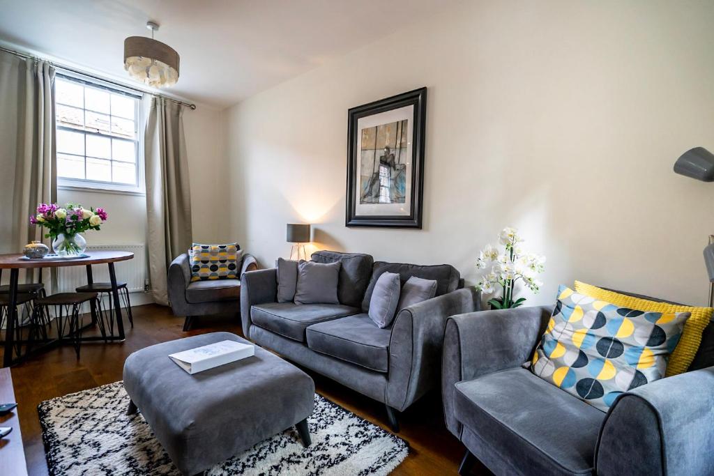 ein Wohnzimmer mit einem Sofa, Stühlen und einem Tisch in der Unterkunft Middlethorpe Manor - No 4 Relaxation and Peace in York