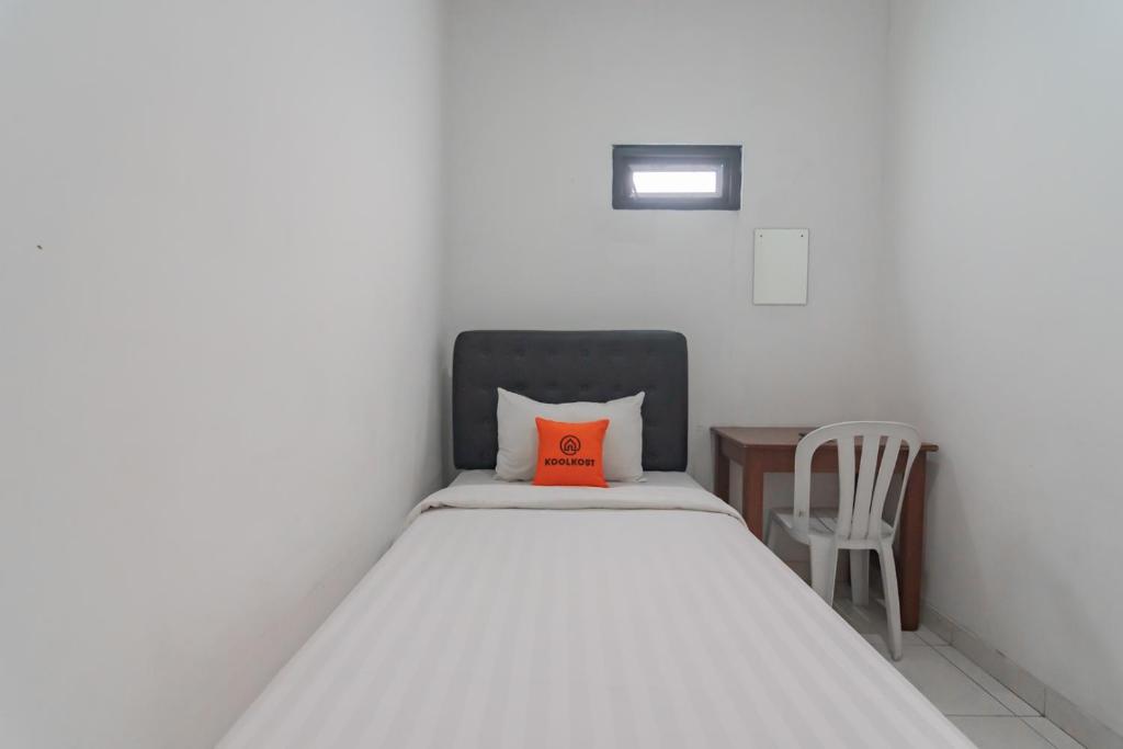 萬隆的住宿－KoolKost near Alun Alun Kota Bandung 2 - Male Only，一间卧室配有一张带橙色枕头的床