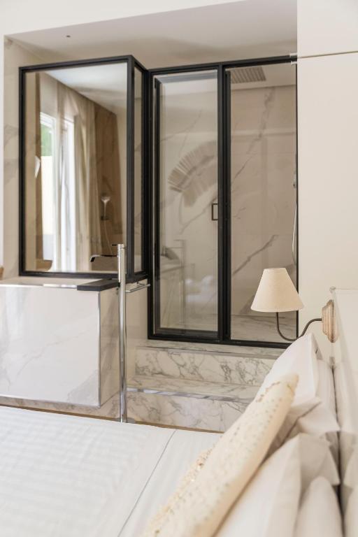 a mirror in a bedroom with a bed and a lamp at Le Palmette Suites in Cagliari