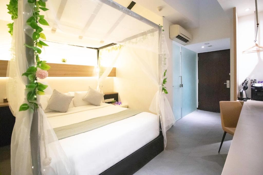 a bedroom with a bed with a canopy at Hotel NuVe in Singapore