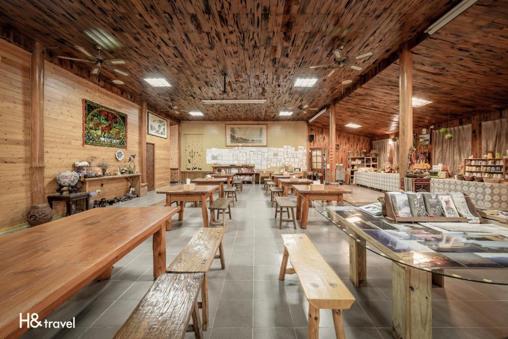 a restaurant with wooden tables and benches in a room at H& Alishan Sunrise B&B in Fanlu