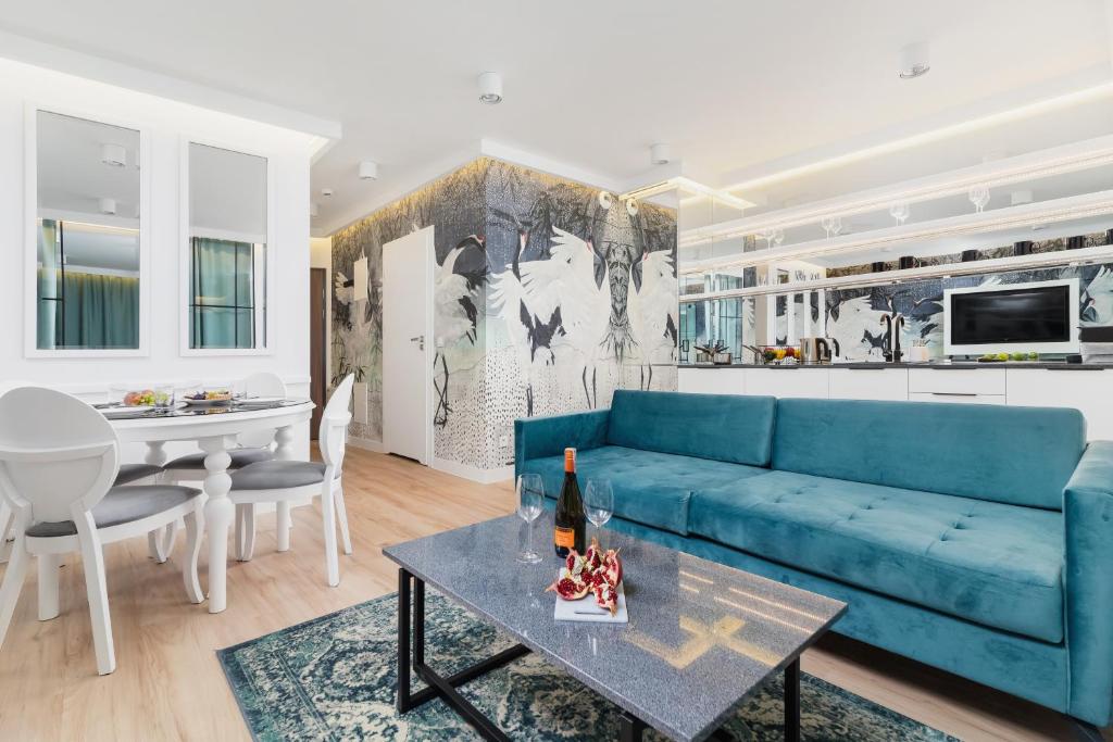Riva Verona Apartments by Renters Prestige في كراكوف: غرفة معيشة مع أريكة زرقاء وطاولة