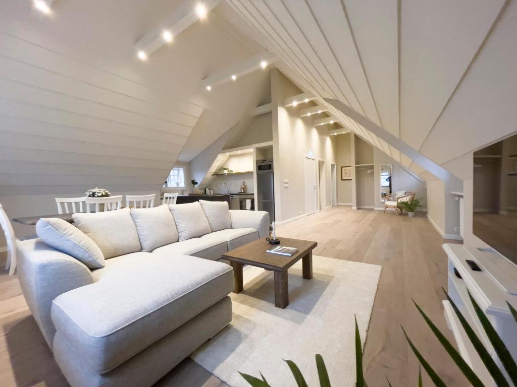 een woonkamer met een witte bank en een tafel bij Kristinsson Apartments in Grindavík