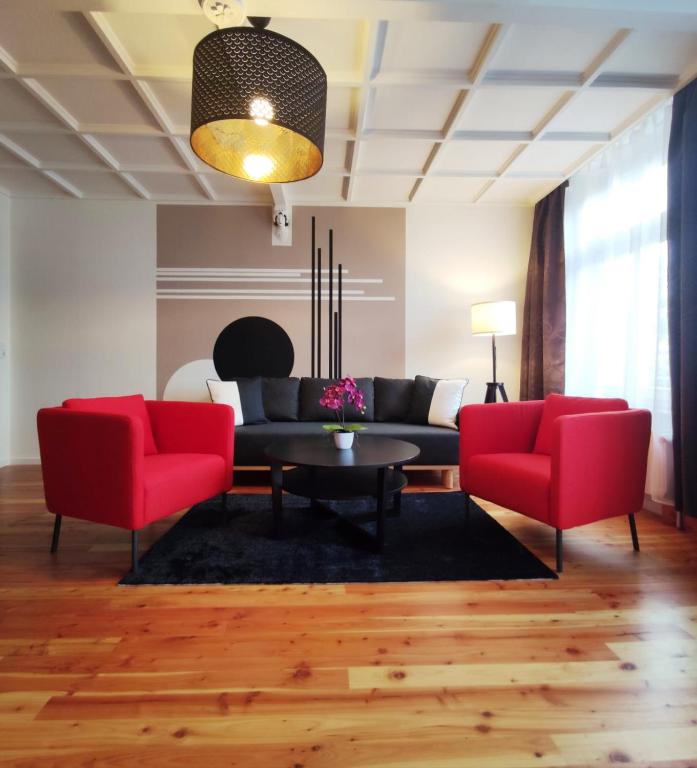 - un salon avec des chaises rouges et un canapé dans l'établissement Exclusive Suite South Central, à Leipzig