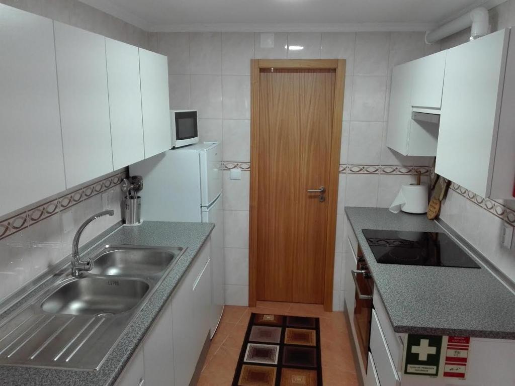 a small kitchen with a sink and a refrigerator at Moradia Machado in Topo