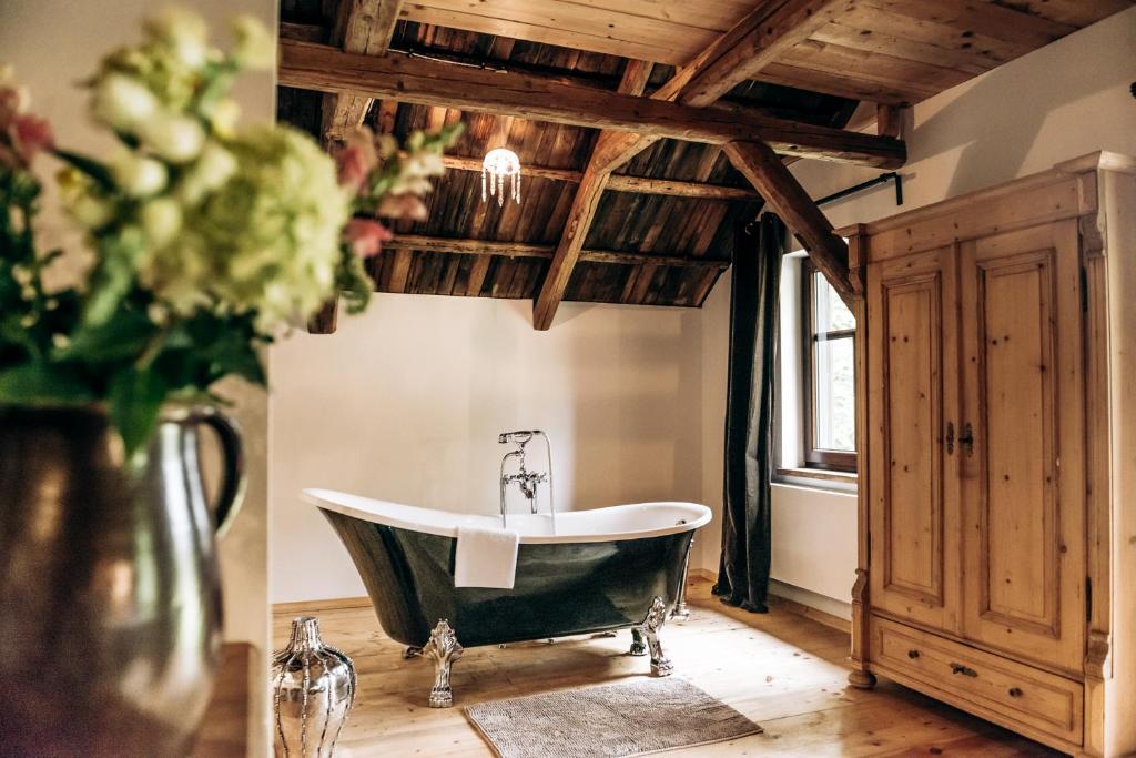 baño con bañera y un jarrón de flores en Ferienhaus Berghütte Vogtland in Klingenthal, en Klingenthal