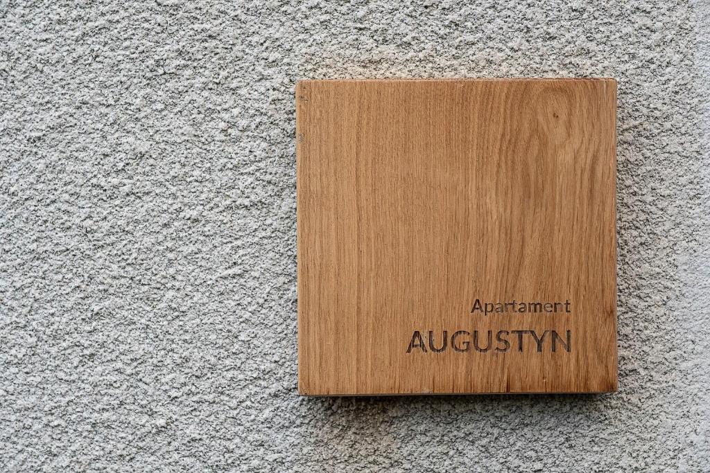 a wooden sign on the side of a wall at Apartament AUGUSTYN in Ostrów Wielkopolski