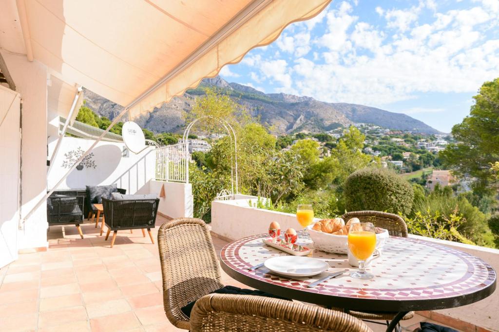 a table with a bowl of food on a balcony with mountains at Don Cayo Resort in Altea la Vieja