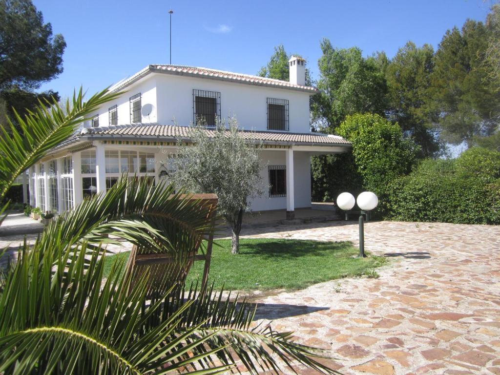 una casa blanca con una palmera delante de ella en Casa Finca Rural La Huerta en Almagro