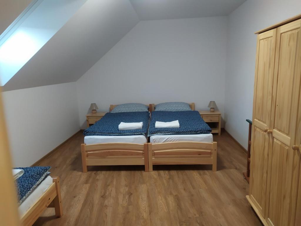 a bedroom with a bed with blue and white sheets at Apartmán Poštolka in Branná