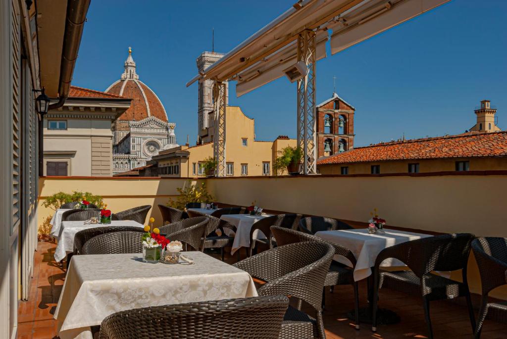 a restaurant with tables and chairs on a balcony at B&B Hotel Firenze Laurus Al Duomo in Florence