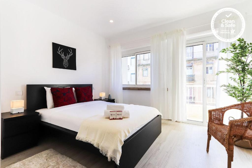a bedroom with a large bed and a large window at Almirante Balcony by Homing in Lisbon