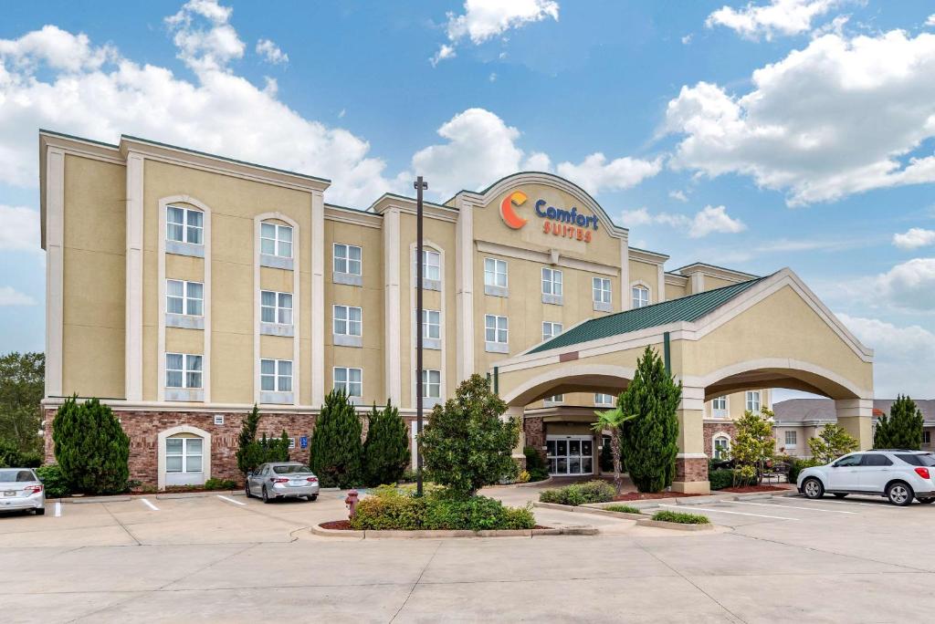 a hotel with cars parked in a parking lot at Comfort Suites in Vicksburg