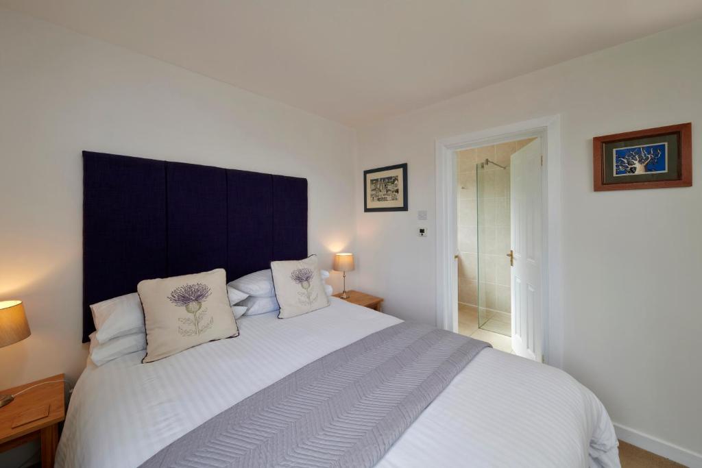 a bedroom with a large white bed with two pillows at By the Brae in Inverness