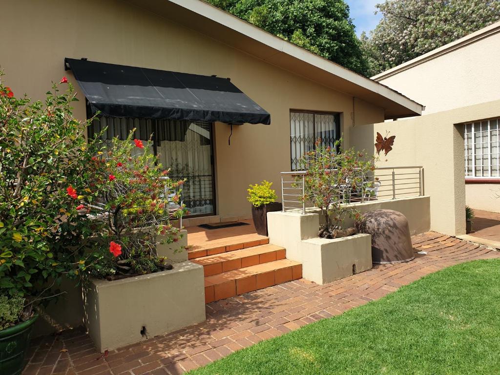 a house with a black awning and some plants at 125 on Van Buuren Road Guest House in Johannesburg