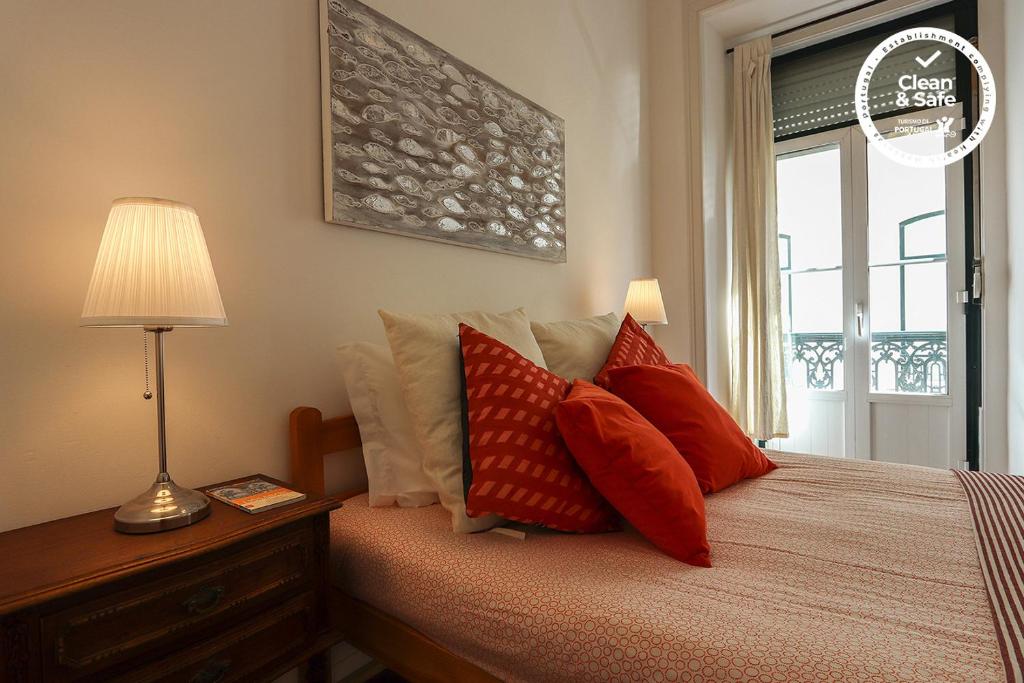 リスボンにあるBairro Alto Classic by Homingのベッドルーム1室(赤い枕のベッド1台、窓付)