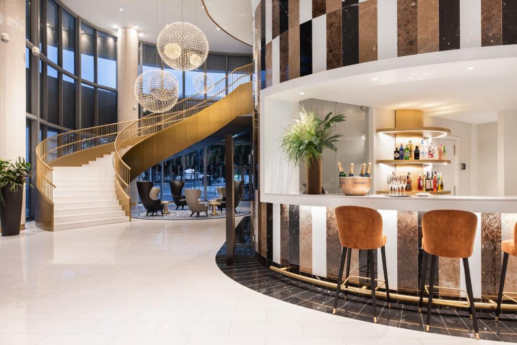 a lobby with a staircase and a bar at Eurostars Universal Lisboa in Lisbon