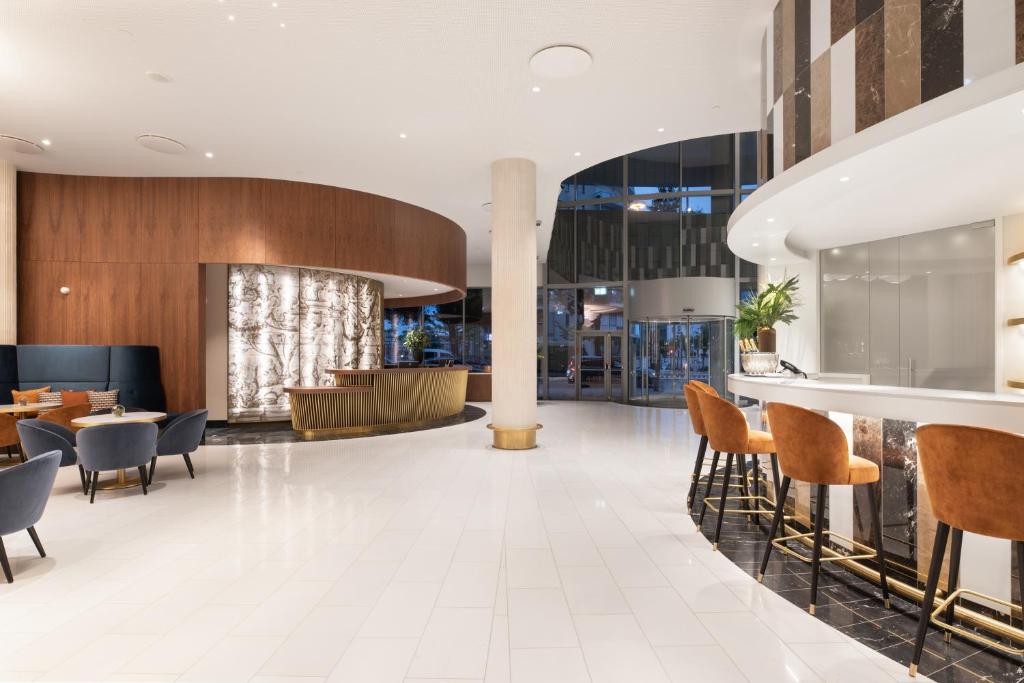 An open lobby combines lounge seating with a long counter and entrance glazing.
