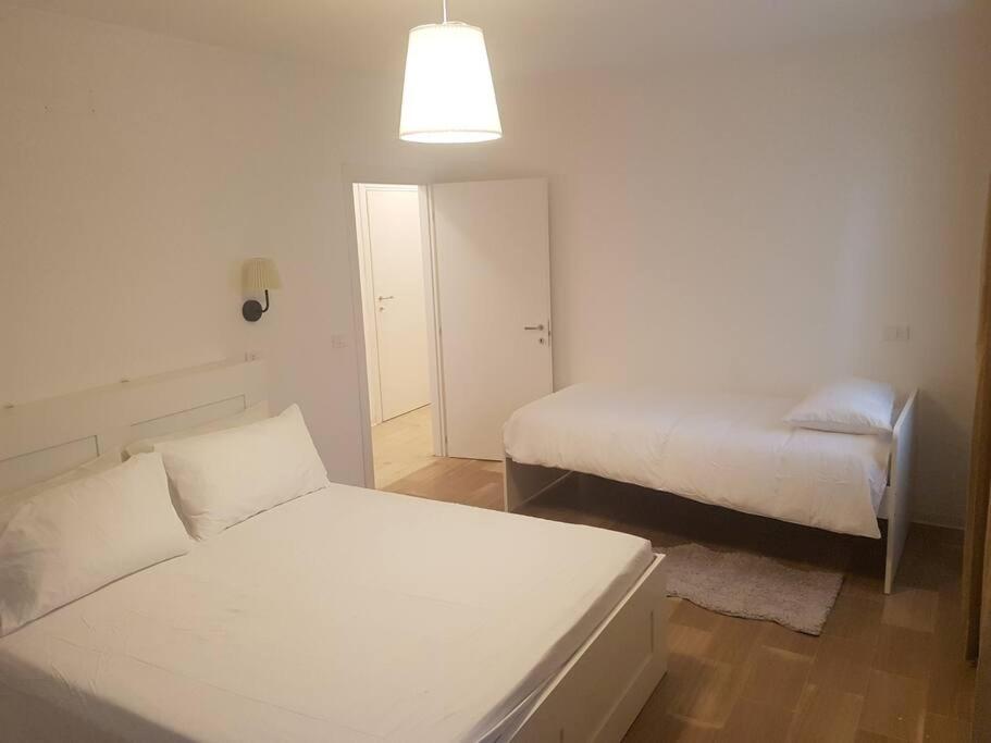 um quarto branco com 2 camas e um candeeiro em Center, 15 minutes from Venice, Parking Miranese em Mestre