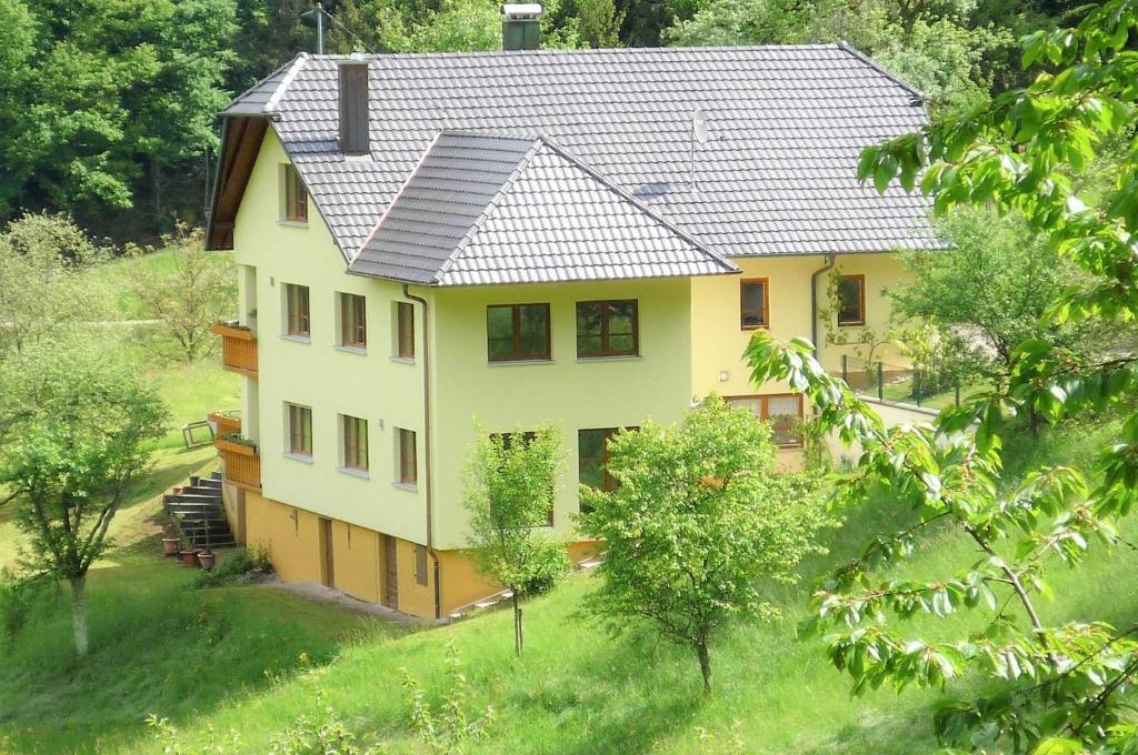 a large yellow house with a metal roof at Ferienwohnung In der Ruhl in Schuttertal