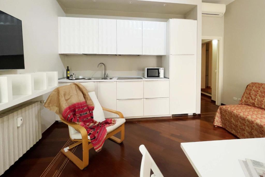 cocina con silla y lavabo en una habitación en Chic Apartment in San Babila, en Milán
