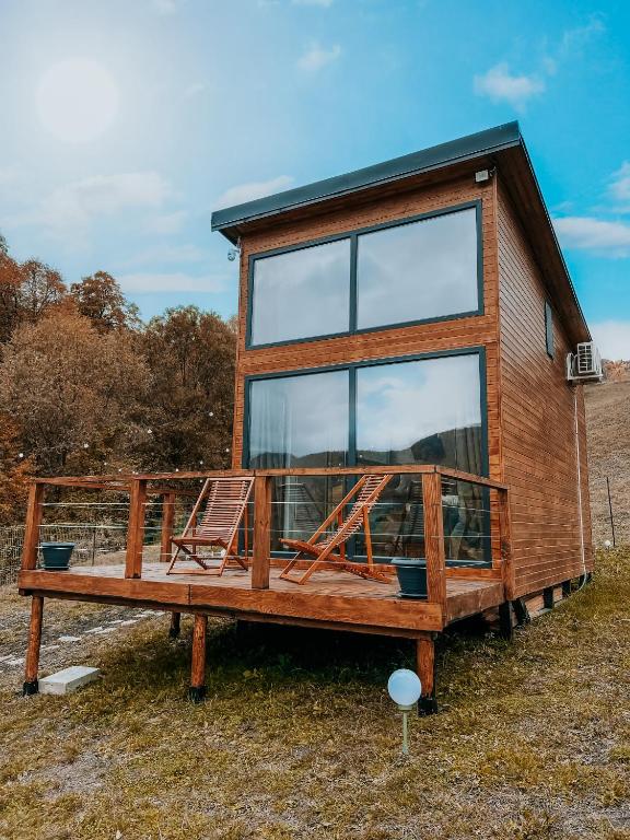 a tiny house with a large window on a field at Roua by NorAtlas Heritage - Adults Only in Varlămul