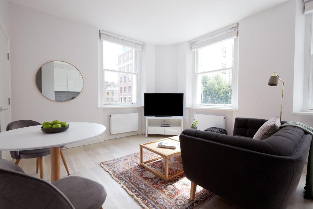 a living room with a couch and a table at 4VH Virginia House, 31 Bloomsbury Way By City Living London in London